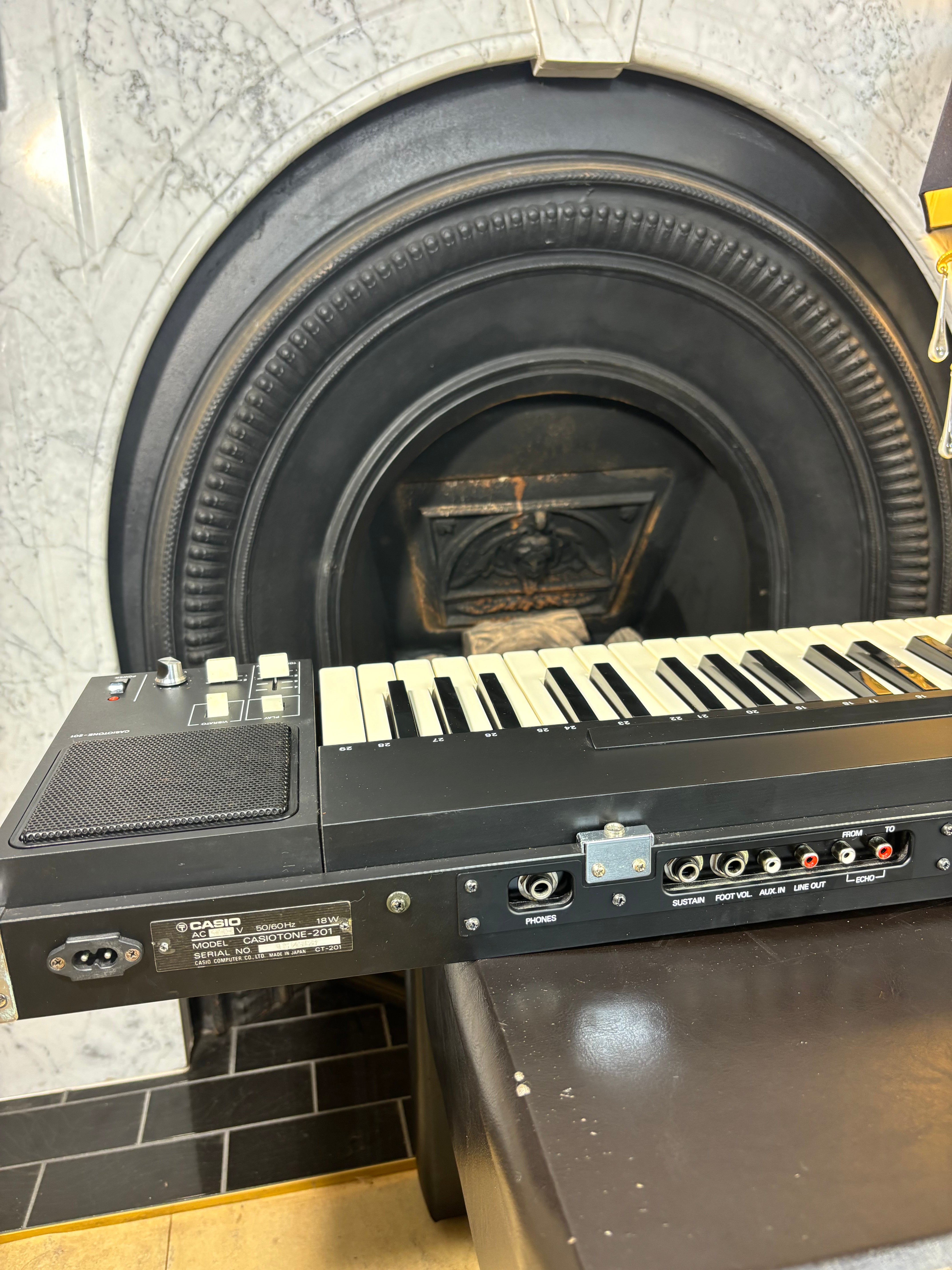 Keyboard in front of a fireplace with a stone wall background