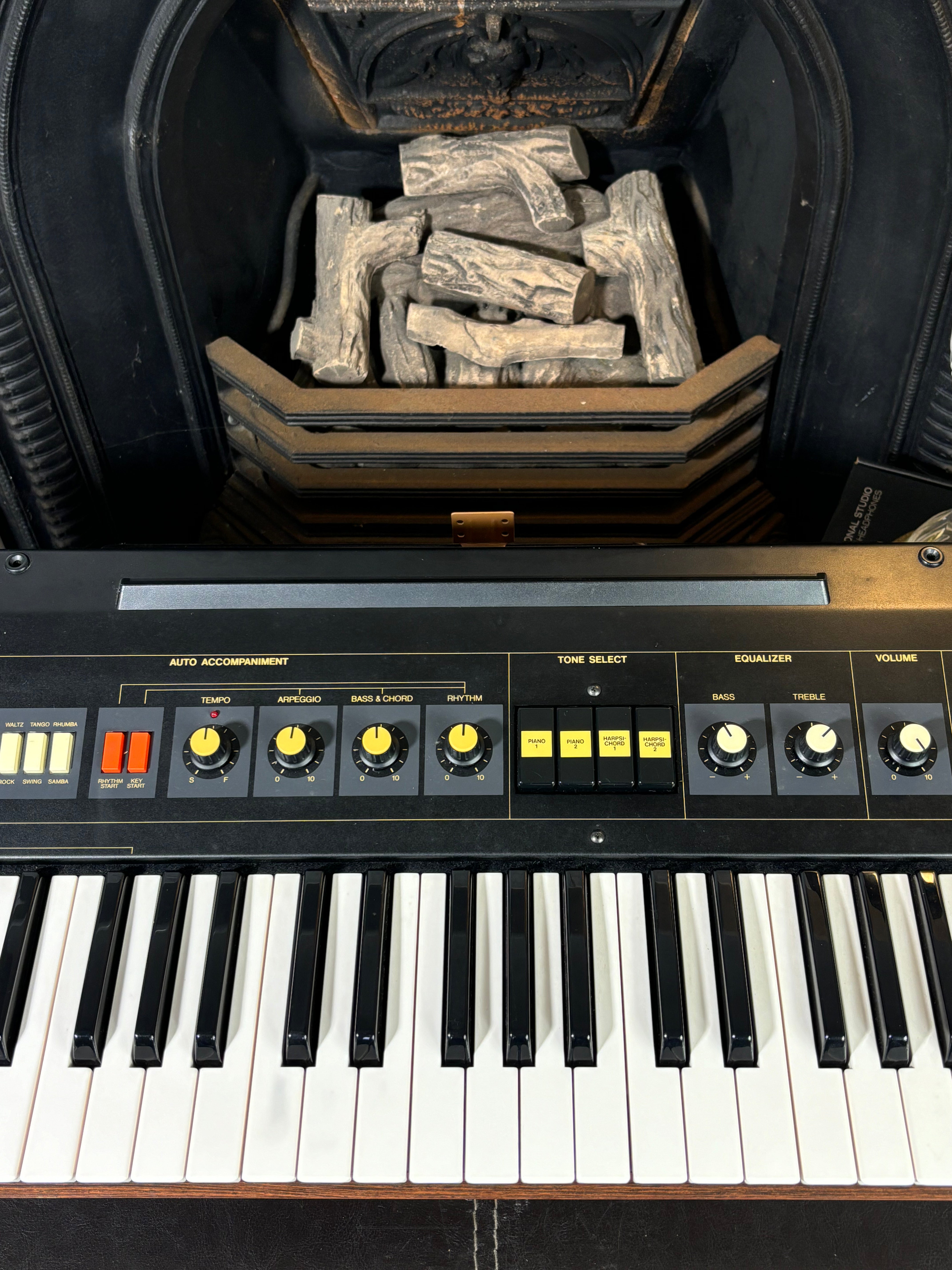 Keyboard instrument with a fireplace.